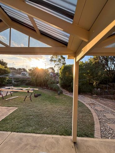 Timber pergola and verandah over a back lawn at sunset by Pixi Builds Melbourne