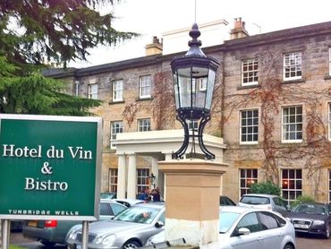 Hotel du Vin & Bistro sign outside a classic stone building with parked cars.