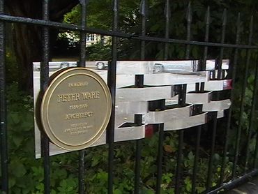Memorial plaque for architect Peter Ware on a metal fence.