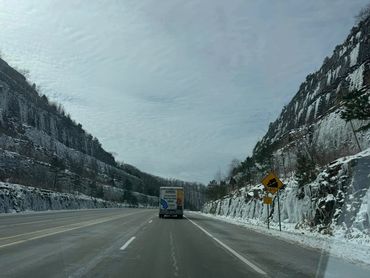 Driving through majestic mountain ranges, where the vast sky stretches endlessly above, offering a b