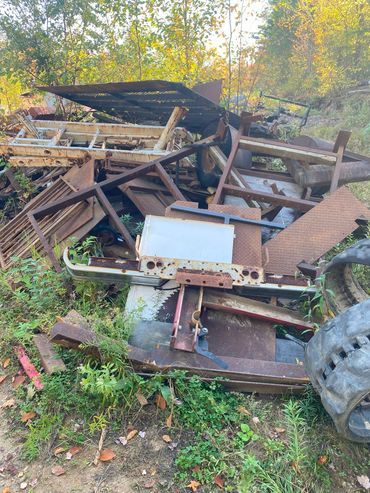 Pile of rusty metal scraps and old machinery parts outdoors.