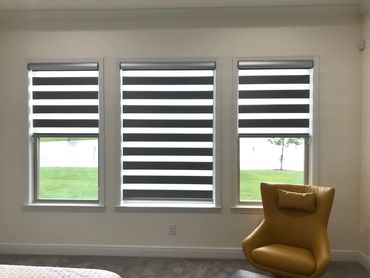 Modern room with three windows and a yellow armchair.