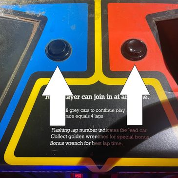 Two black arcade buttons on a colorful game panel.