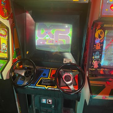 Vintage arcade racing game with two steering wheels.