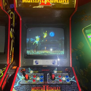 Classic Mortal Kombat arcade machine with game on screen.