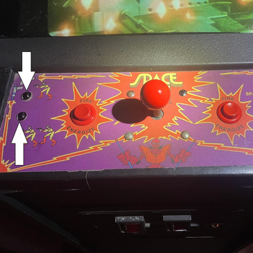 Close-up of a vintage arcade game control panel with joystick and buttons.