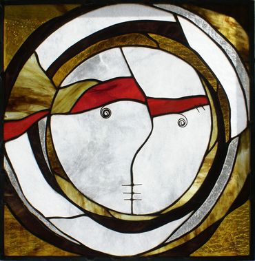 Vitrail multicolor représentant un visage à la bouche cousue