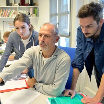 A teacher showing students something on a computer screen
