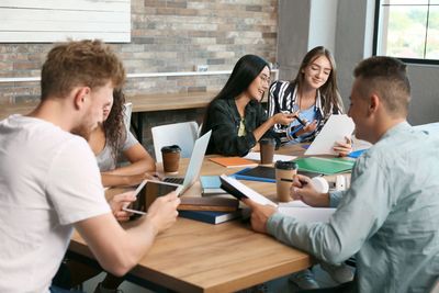 People at work sitting around a table looking relaxed and happy