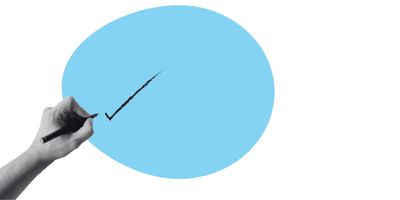 A hand holding a pen and drawing a tick