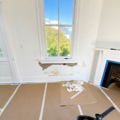 Water-damaged plaster wall repair beneath an original window in a historic Charleston, SC home.