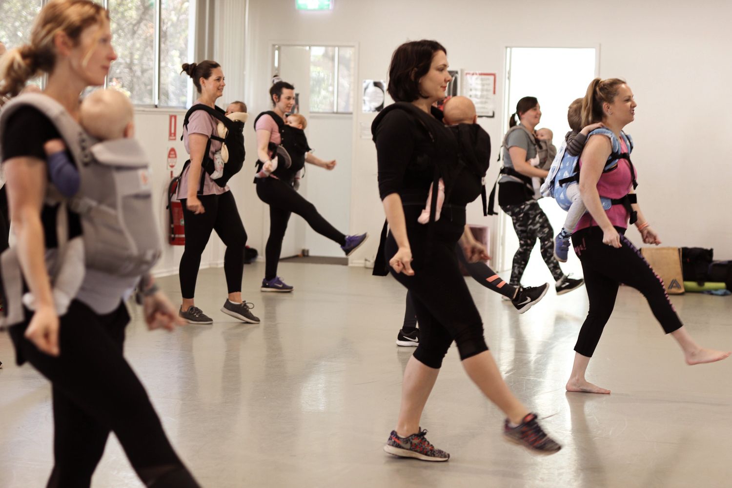 Group of women dancing with their babies in carriers