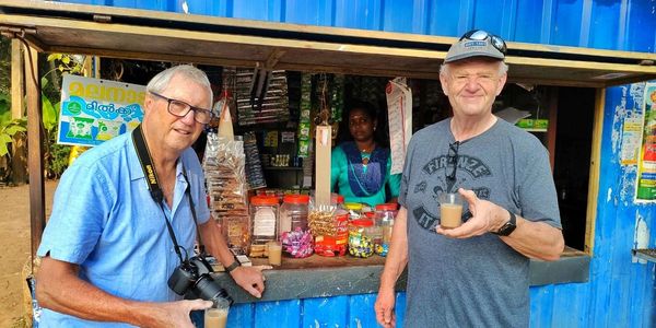 Two men enjoying tea at a small shop.