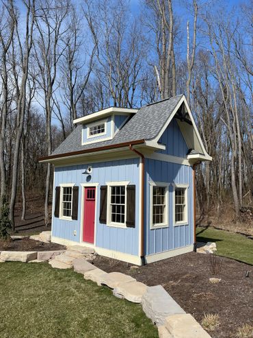 Garden shed with board and batten siding and cedar shutters