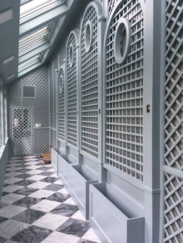 Indoor corridor with lattice-patterned walls and checkered floor.
