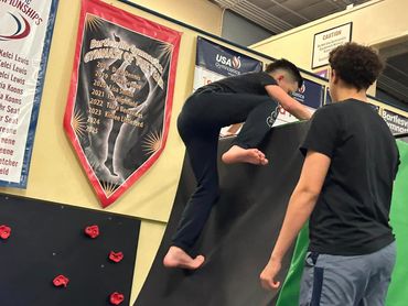 a little boy climbing up with the help of an adult