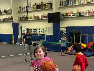 a little girl with a basketball looking at the camera