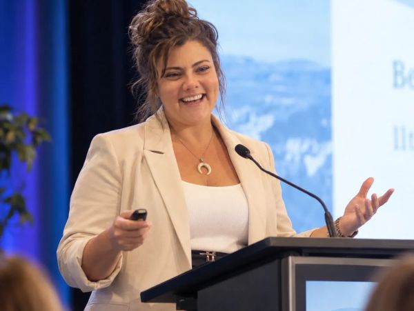 Woman speaking confidently at a podium during a presentation.