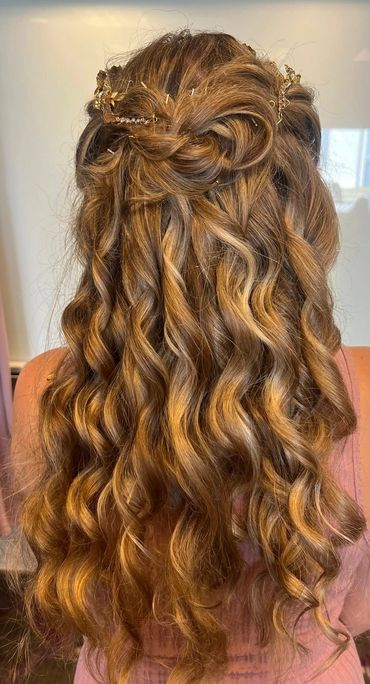 Long curly hair styled with a decorative hair accessory.