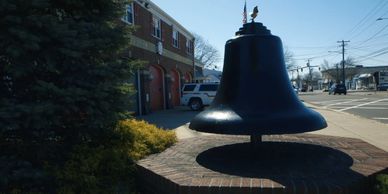 Bell in front of the East Meadow Fire Department building, from "Generation Rescue."