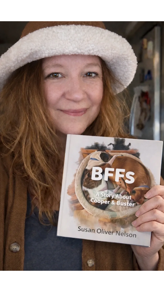 Susan Oliver Nelson holding her book BFFs A Story About Cooper & Buster