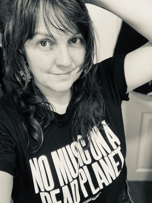 Woman wearing a shirt with a message about music and the planet.