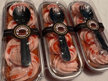 Three containers of swirled pink and white dessert with black spoons.
