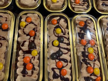 Rows of decorated dessert trays with colorful toppings.