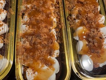 Desserts topped with caramel sauce and crumbled pieces.