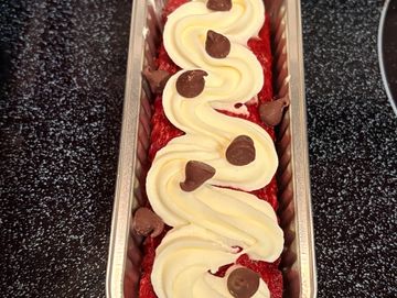 Dessert with cream and chocolate chips in a metal container.