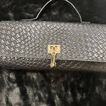 Black textured handbag with a gold clasp