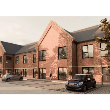 Modern brick apartment building with cars parked outside.