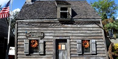 Historic wooden house with autumn wreaths and American flag.