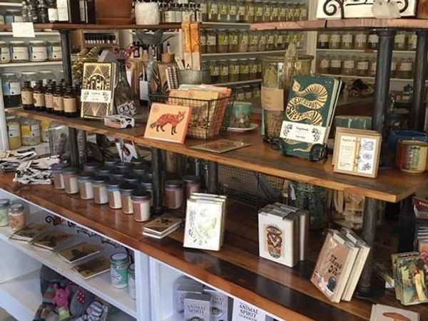A rustic store shelf filled with candles, books, and decorative items.