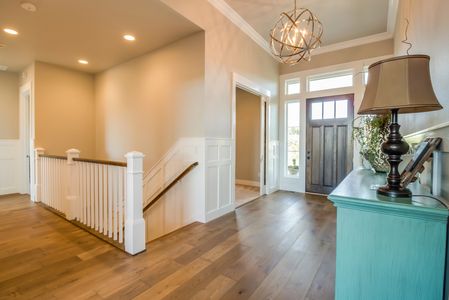 Entry to a custom home with tall ceilings, crown molding, and wainscot pannelling. 