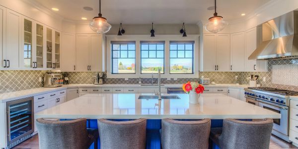 Custom kitchen with tile backsplash and blue island cabinets.
