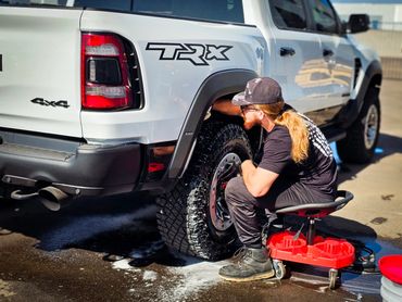 Hand cleaning the wheels and tires of a ram trx.