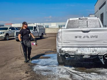 Hand washing a Ram TRX and spraying shampoo foam on the truck.