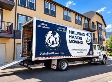 Helping Hands Moving and Maids truck parked outside a multi-unit residential property in Utah.