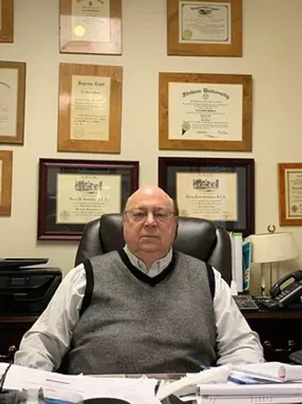 Man sitting at desk with certifications on the wall.