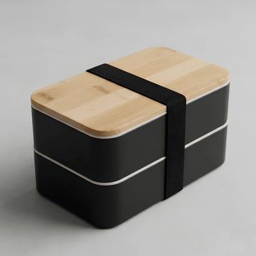 Lonchera negra con tapa de madera y banda elástica.