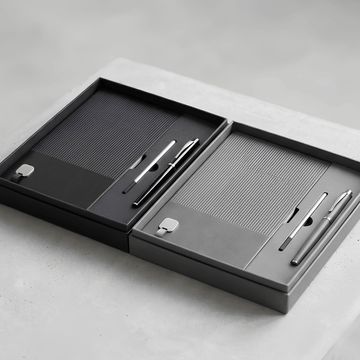 Cuadernos con bolígrafos en estuches elegantes blanco y negro.