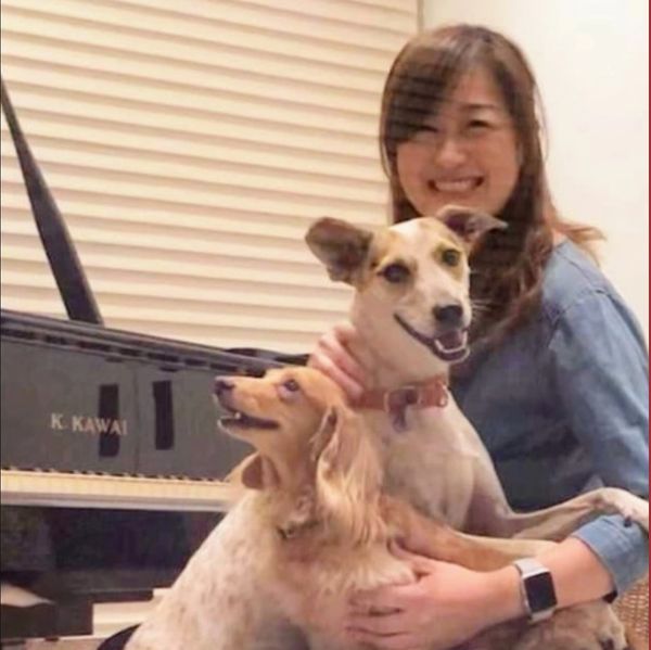 Tina Yen playing with two dogs and posing for a photo
