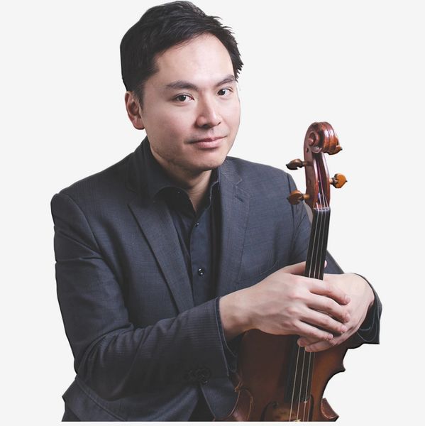 Andy Lin in a black suit, holding a violin, and posing for a photo