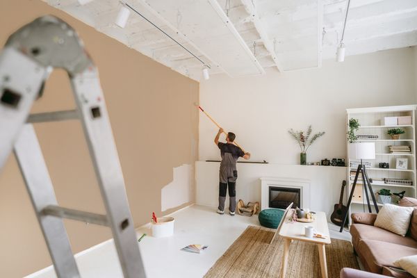 Painter finishing beige living room.