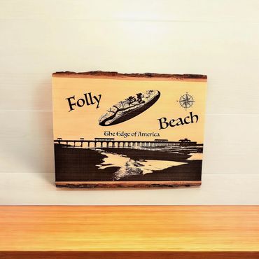 Wooden plaque featuring Folly Beach and its pier with compass and slogan.