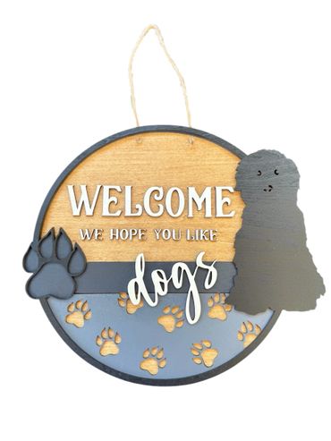 Round wooden welcome sign with dog silhouette and paw prints.