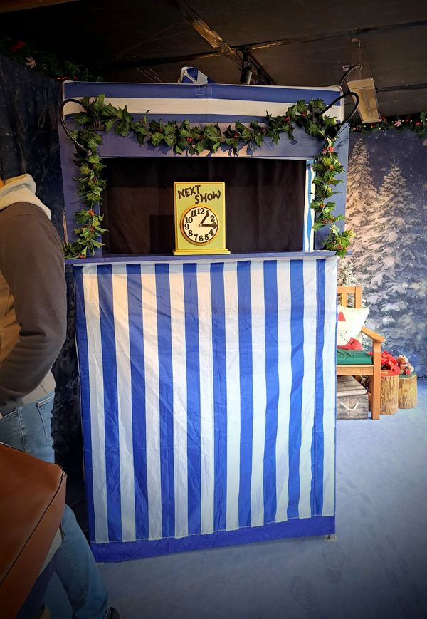 A decorated puppet stage in a Christmas Market hut.