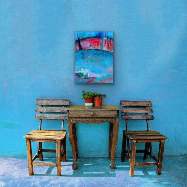 Rustic table with two wooden chairs against a blue wall.