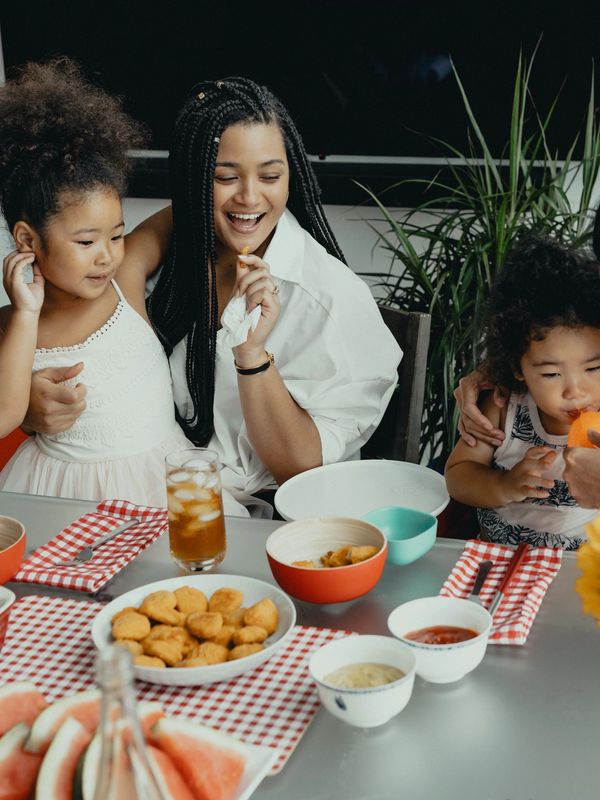 A joyful mother with her two children enjoying a meal together.